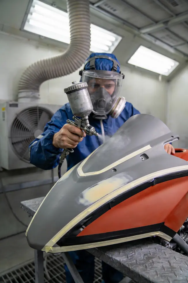 Technician performs thorough inspection and cleaning of a plastic fairing to identify scratches, cracks, and adhesion concerns before repaint.
